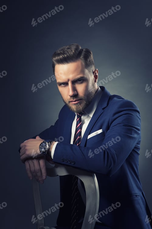 Preview: Young Handsome Bearded Caucasian Man With Blue Eyes Sitting On Chair. Perfect Skin And Hairstyle