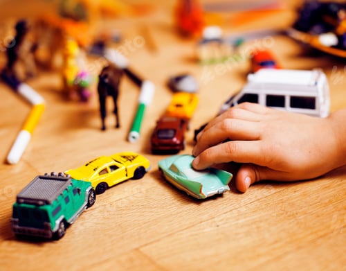 Preview: Child's Hand Playing with Toy Cars on Floor