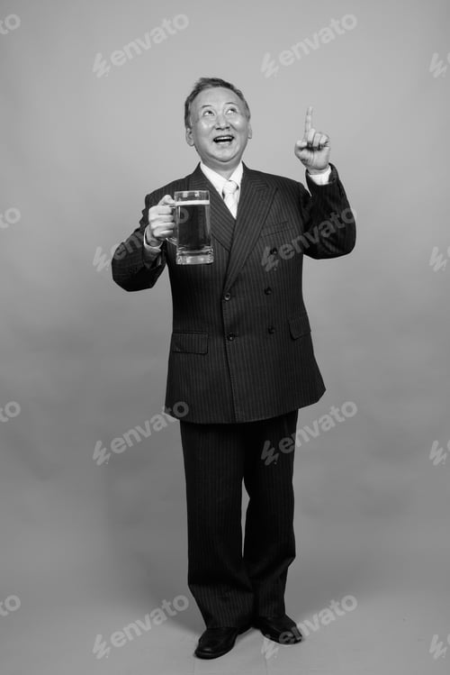 Preview: Portrait Of Mature Asian Businessman Against Gray Background