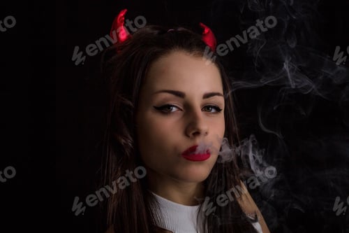 Preview: Woman With Devil Horns And Cigarette Smoke Posing On Black Background