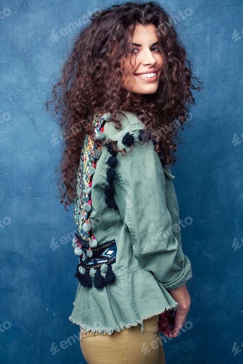 Preview: Young Pretty Woman With Curly Brunette Hair Posing Cheerful On Blue Background, Lifestyle People