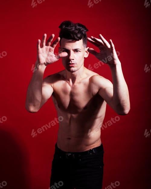 Preview: Young Fashion Style Man With Naked Torso Dancing Emotional Posing On Red Background, Lifestyle