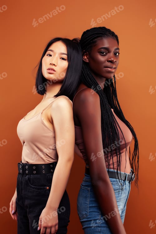 Preview: Young Pretty Asian And Afro Woman Posing Cheerful Together On Brown Background, Lifestyle Diverse