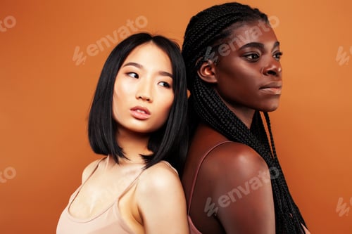Preview: Young Pretty Asian And Afro Woman Posing Cheerful Together On Brown Background, Lifestyle Diverse