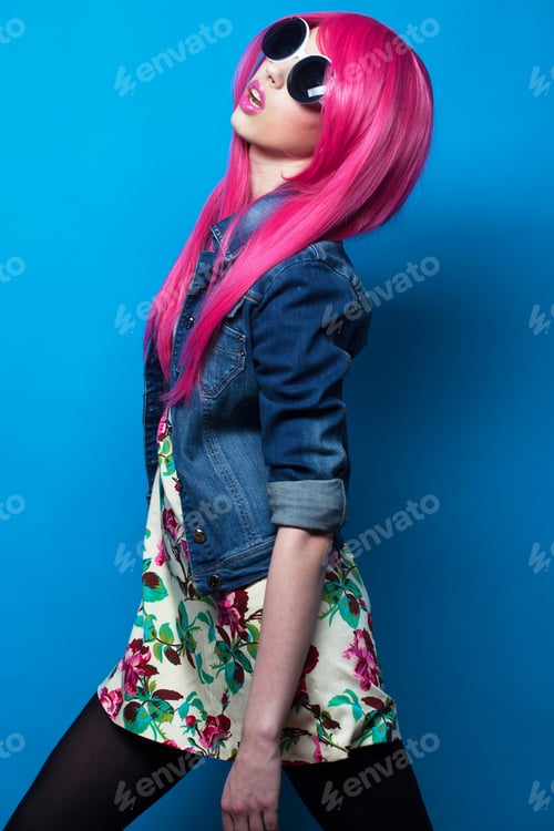 Preview: Fashion And Beauty Concept: Young Fashion Female Model With Pink Hair And Big Sunglasses Over Blue