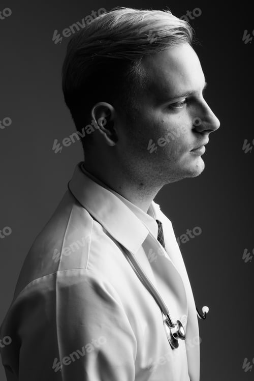 Preview: Young Handsome Man Doctor With Blond Hair Against Gray Background