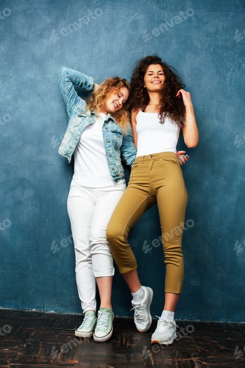 Preview: Young Pretty Teenage Girls Friends With Blond And Brunette Curly Hair Posing Cheerful On Blue