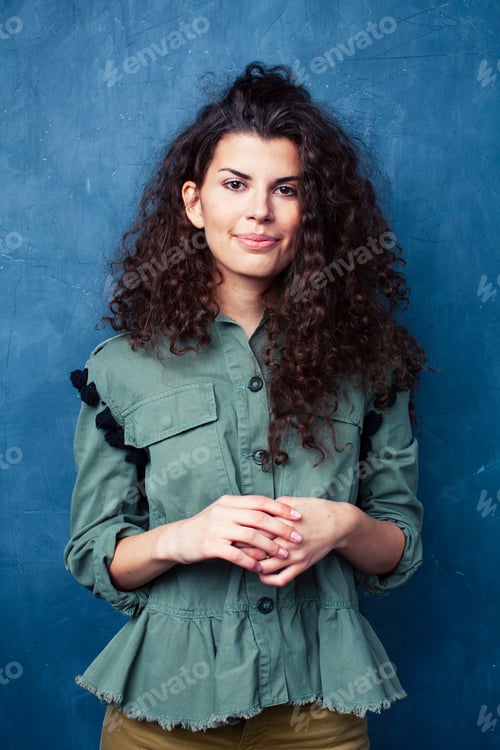 Preview: Young Pretty Woman With Curly Brunette Hair Posing Cheerful On Blue Background, Lifestyle People