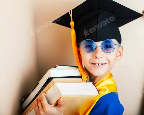 Preview: Little Cute Preschooler Boy In Glasses With Books At Home Education In Graduate Hat Smiling Posing