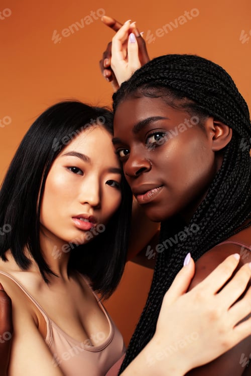 Preview: Young Pretty Asian And Afro Woman Posing Cheerful Together On Brown Background, Lifestyle Diverse