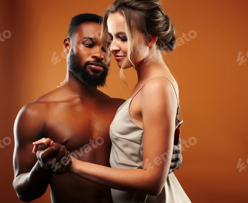 Preview: Young Pretty Couple Diverse Races Together Posing Sensitive On Brown Background, Lifestyle People