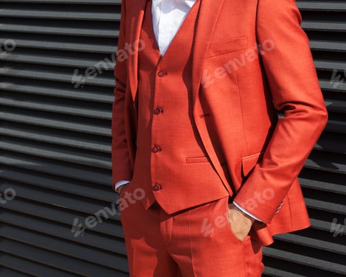 Preview: Part Of The Body. A Young Businessman In A Fashionable Red Suit Posing Against A Wall Of Iron