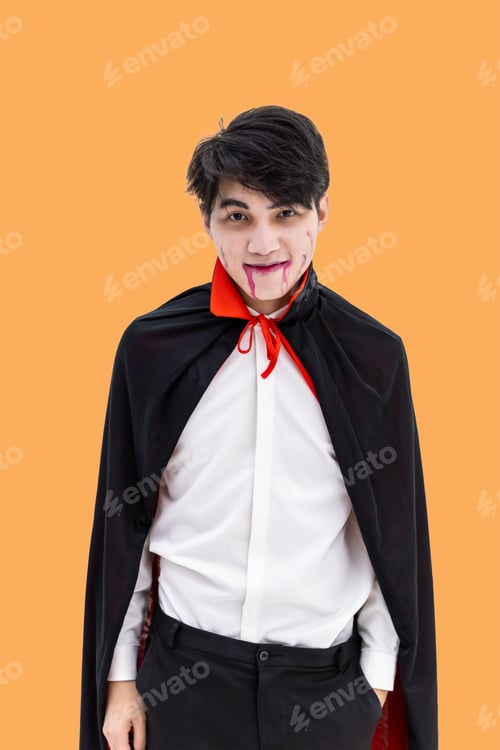 Preview: Asian Man Wearing Halloween Costume As Vampire Dracula On Orange Background, Looking At Camera