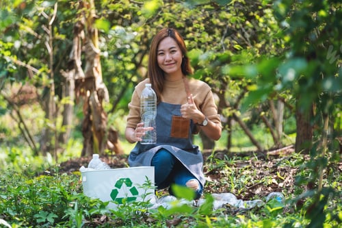 Preview: A Beautiful Asian Woman Making Thumbs Up Hand Sign While Collecting Garbage Plastic Bottles Into A