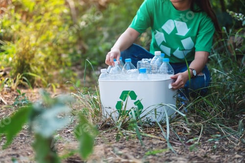 Preview: A Woman Collecting Garbage Plastic Bottles Into A Recycle Bin In The Outdoors