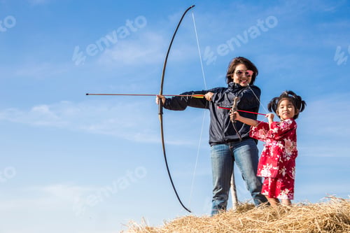 Preview: Asian Mother And Daugther Playing Arrow On Straw And Clear Sky