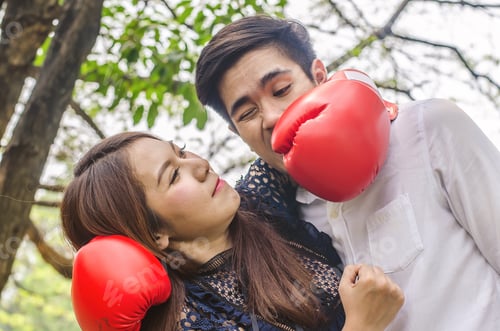 Preview: Couple Fighting In Boxing Red Gloves On Park Background. Problems In Relationship