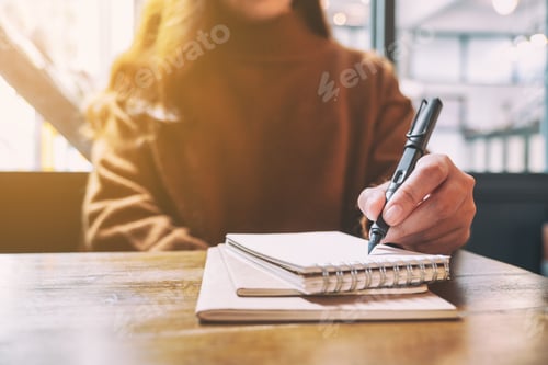 Preview: Closeup Image Of A Woman Writing On Blank Notebook With Fountain Pen On Wooden Table