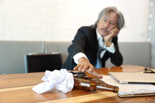 Preview: Senior Businessman Got Stress From Failure In Business Trying To Hold Alcohol Bottle On Table With
