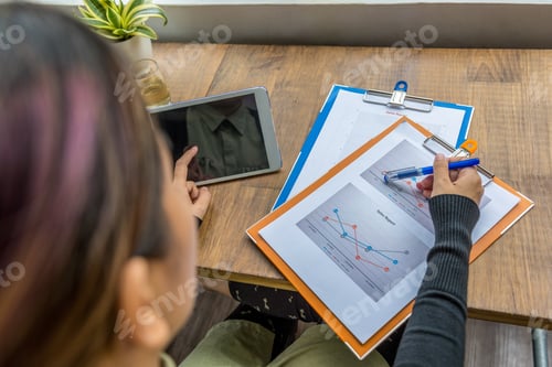 Preview: Top View Of Woman Using Tablet And Pointing At Diagram