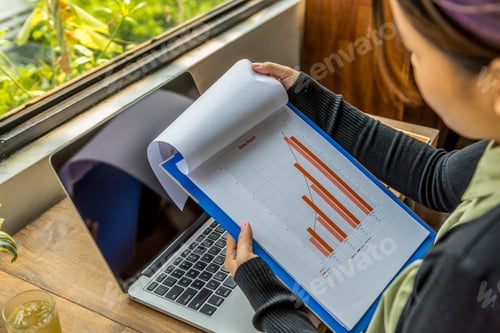 Preview: High Angle View Of Asian Woman Holding Sales Report Document