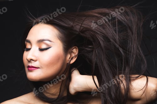Preview: Portrait Of Young Asian Woman With Makeup Long Hair On The Black Isolated Posing.