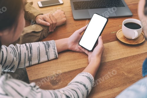 Preview: People Using And Looking At The Same Mockup Mobile Phone On Wooden Table Together