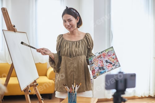 Preview: Creative Influencer An Online Streaming Painting Demonstration. A Young Female Asian Artist Holding