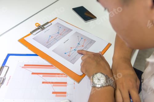 Preview: Young Businessman Checking Finance Report With Finger