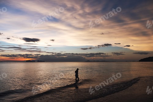 Preview: Silhouette Image Of A Woman Walking In The Sea Before Sunset
