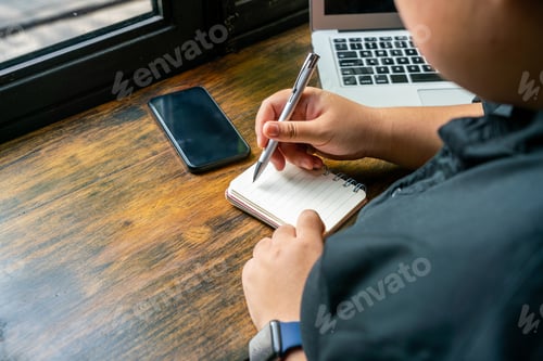 Preview: Freelancer Writing Daily Notebook Next To Computer And Cellphone