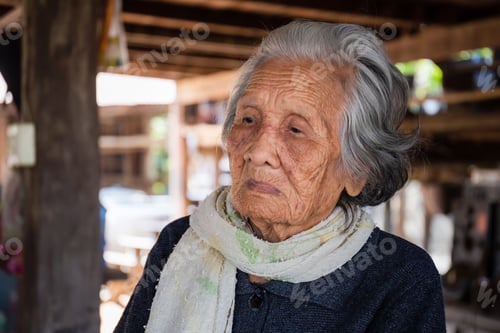Preview: Selective Focus Of Older Woman With Short Grey Hair Sitting At Home In The Countryside Of Thailand
