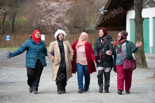Preview: Group Of Muslim Friends Walking And Laughing Together. Winter Clothing.
