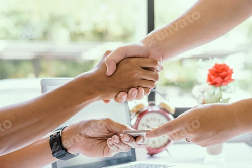 Preview: Two Business Man Pay Money And Handshake ,A Clock On The Table ,A Laptop, And A Floral In The