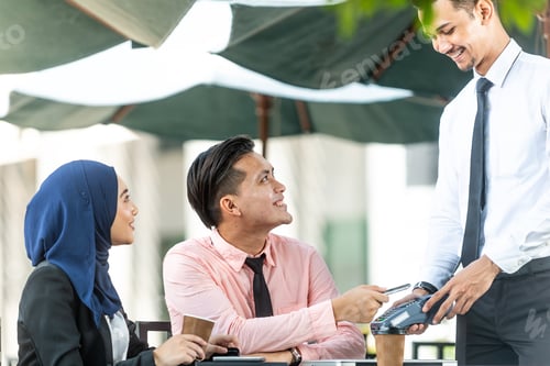 Preview: Waiter Interacting With Muslim Customers Using Bank Terminal To Process And Acquire Mobile Payment