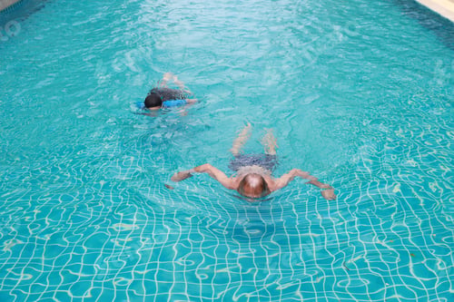 Preview: High Angle View Happy Elderly Caucasian Husband And Elderly Asian Wife Swimming In Pool During