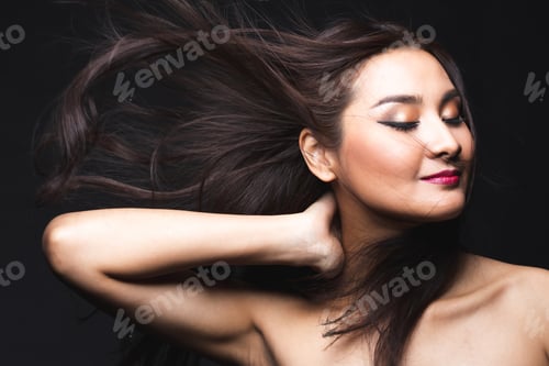 Preview: Portrait Of Young Asian Woman With Makeup Long Hair On The Black Isolated Posing.