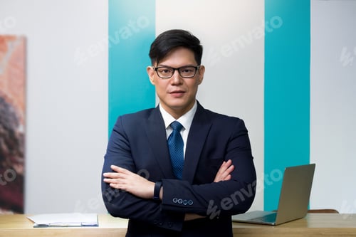 Preview: A Business Person Car Rental Operator Or Lodging Wearing Blue Suit And Glasses Is Standing With