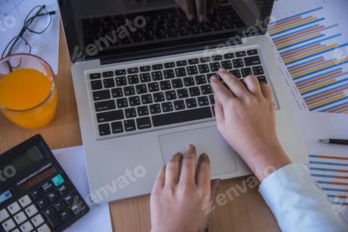 Preview: Hands Of Businessman Working On Laptop Computer With Data Charts