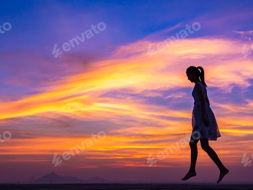 Preview: Woman Silhouette Walks at Colorful Sunset Sky