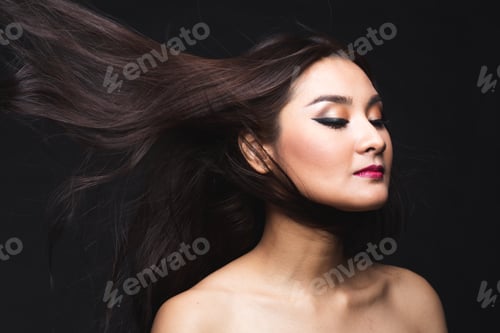 Preview: Portrait Of Young Asian Woman With Makeup Long Hair On The Black Isolated Posing.