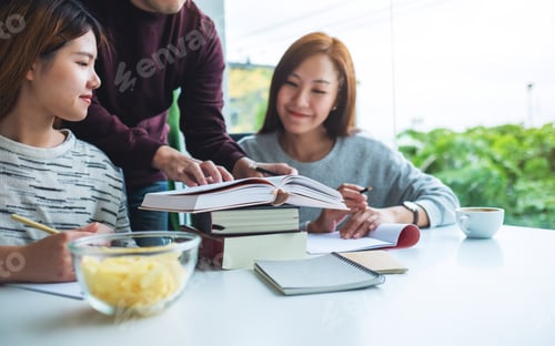 Preview: Group Of Young Students Tutoring And Catching Up Workbook Together