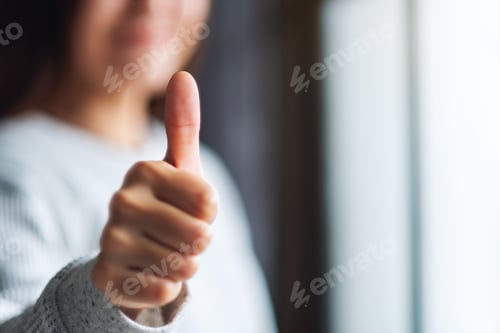 Preview: Closeup Image Of A Woman Making And Showing Thumbs Up Hand Sign