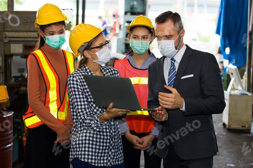 Preview: Caucasian Handsome Bearded Industrial Plant Owner And Female Engineer With Staff Standing In Front