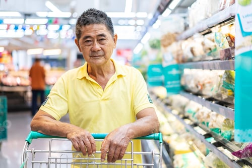 Preview: Front View Of A Asian Senior Man Shopping Trolley Choosing Other Products In Supermarket