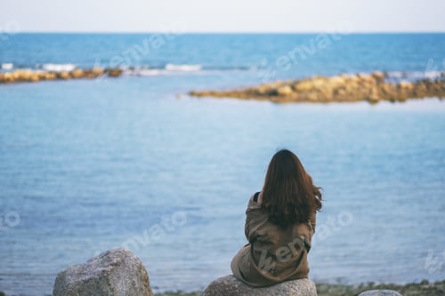 Preview: A Beautiful Asian Woman Enjoy Sitting On The Rock By The Seashore