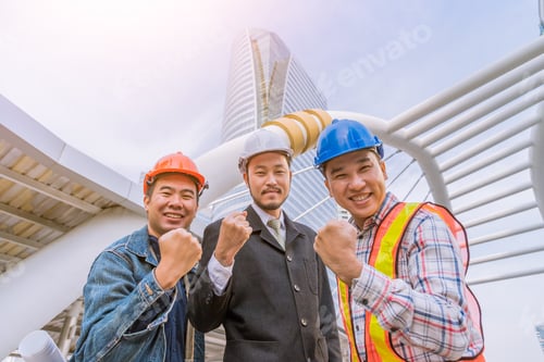 Preview: Successful Businessman And Engineer At Outdoor Site With Clench Fist
