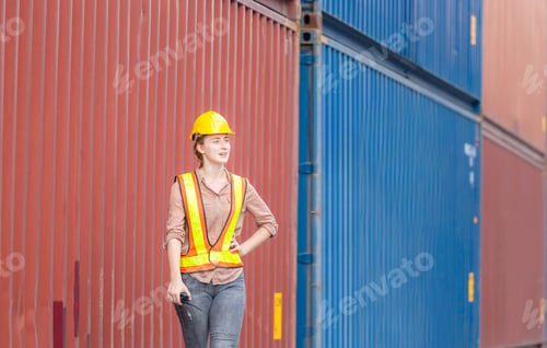 Preview: Woman Engineer In Hardhat And Safety Vest Holding Holding Two-Way Radio Control Loading Containers