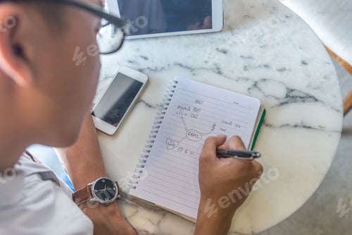 Preview: Rear View Of Man Writing Goal Into The Notes