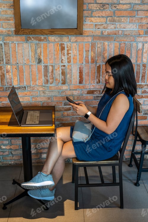 Preview: Young Asian Woman Sitting With Laptop On Wooden Table